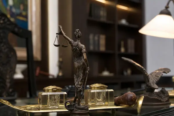 Az igazságosságot jelképező Justitia-szobor az ügyvédi iroda íróasztalán